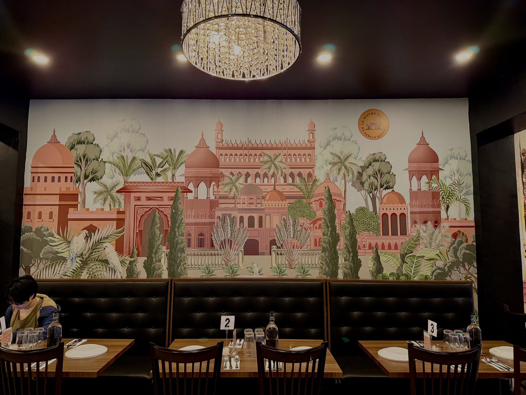 Hand-painted Indian palace mural above the leather booths at Le Bistro Indien