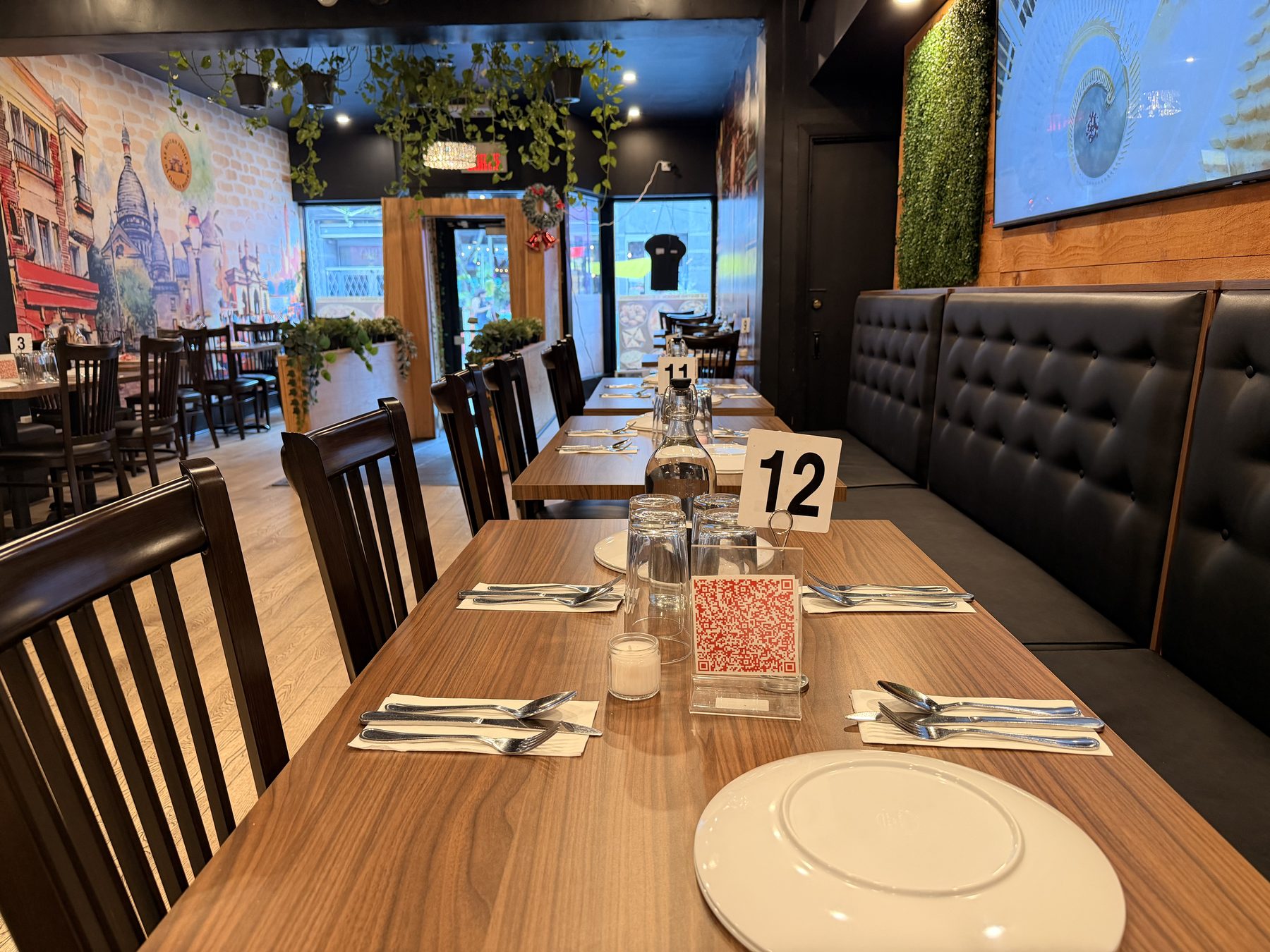 Set tables and booth seating inside the dining room at Le Bistro Indien